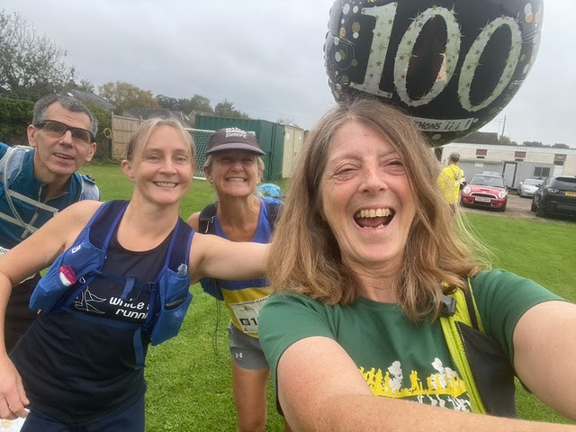 Di with friends, holding her 100 marathon balloon